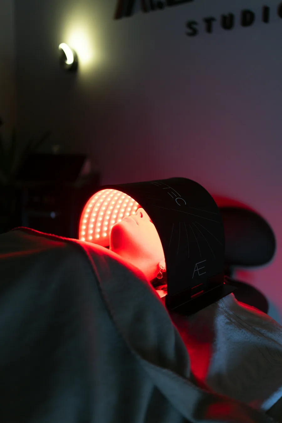Séance de luminothérapie : masque LED rouge posé sur le visage d'une cliente
