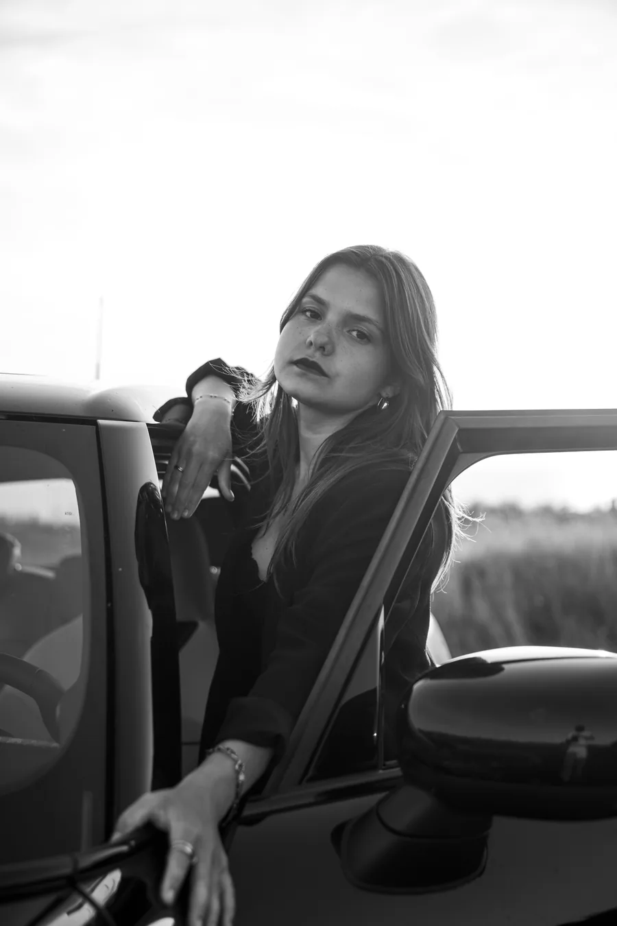Femme accoudée à la portière d'une MINI, en noir et blanc