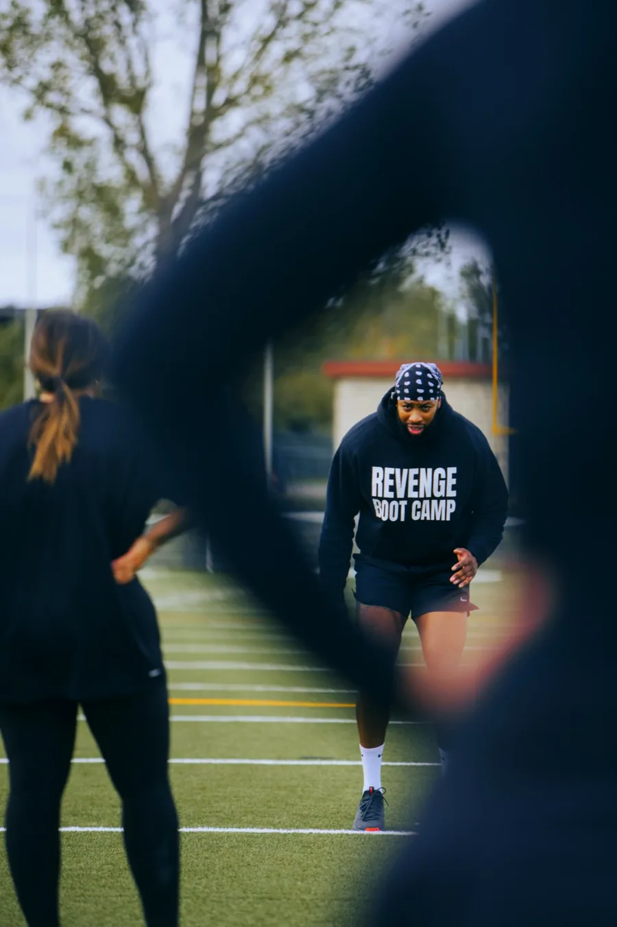 Participante à l'effort pendant un exercice, aperçue entre deux silhouettes